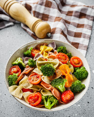 delicious colored farfalle pasta on a stone background