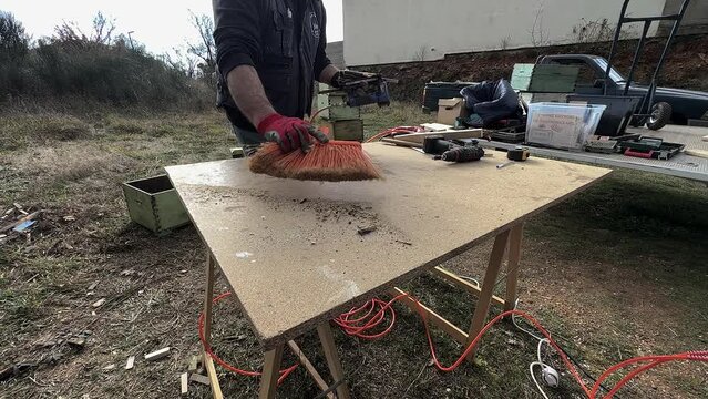 Carpenter Wipes Sawdust Off His Workbench Slow Motion  