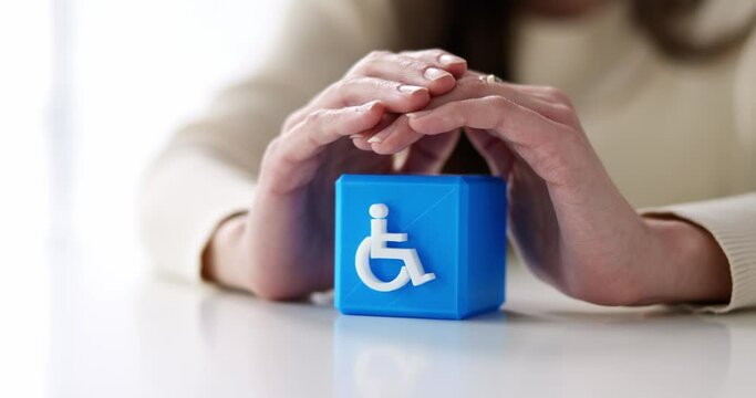 Person's Hand Protecting Blue Cubic Block