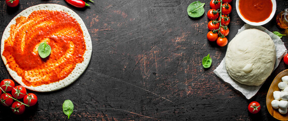 Preparation pizza. Rolled out dough with tomato paste.