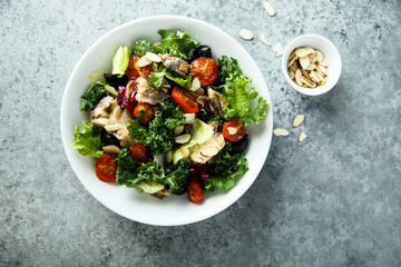 Healthy green salad with roasted tomatoes and fish