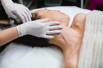 Fototapeta na wymiar Cosmetology massage of neckline in beauty salon