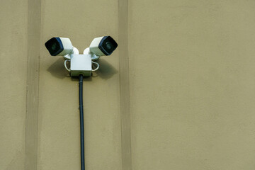 A modern surveillance camera mounted on the wall of a guarded building, close-up. Security and theft protection systems. Protection of private territory, banking system and personal belongings.
