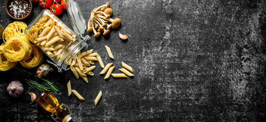 Raw pasta with garlic, spices and oil in a bottle.