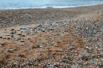Sea sand with pebbles with wave