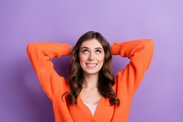 Fototapeta na wymiar Portrait of pretty positive girl arms behind head look up empty space isolated on purple color background