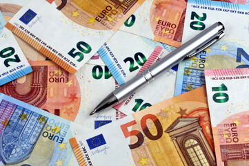 Stylo posé sur des billets de banque en euros