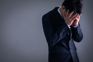 顔を覆うスーツの男性
