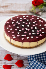 Blueberry cheesecake decorated with sweet hearts on wooden table