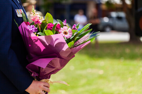 Person presenting flowers to lay on remembrance day
