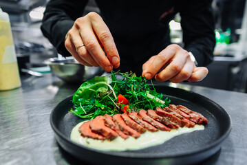 chef hand preparing Roastbeef salad with vegetables on restaurant kitchen