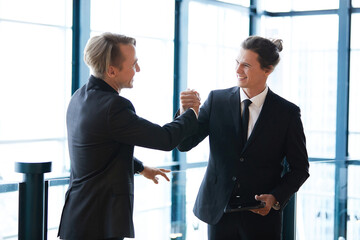 Fototapeta premium businessman shaking hands with friends and having fun in the office