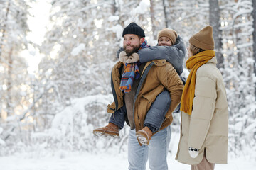 Family having fun together with their daughter outdoors during their walk in the forest