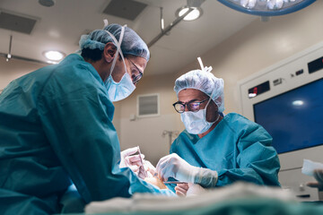 surgeons in medical masks operating patient in operating room