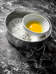 Flour in sieve with egg.