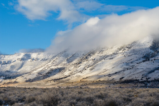 Clouds Rolling Over Oregon Desert Mountains Covered In Snow
