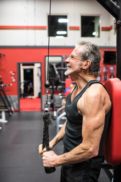 Fit Elderly man working out with triceps pulldown