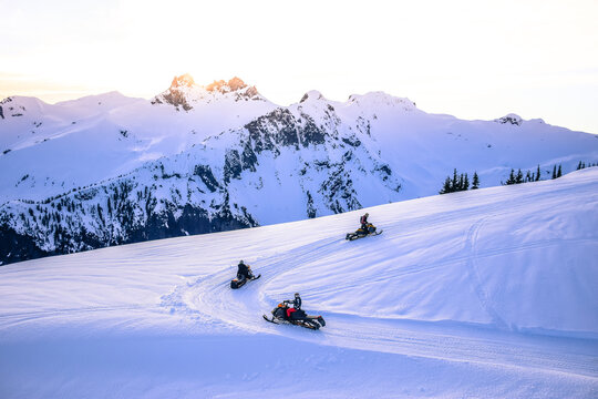 People driving snowmobiles, on top of the Callaghan Valley, Whistler, British Columbia, Canada