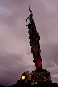 Prayer flags and fire pit with stormy sky.  Tagong, Sichuan, Chian (Tibet)