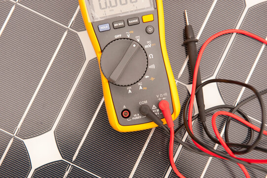 Closeup of a photovoltaic panel with a multimeter (or voltmeter)