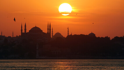 The beautiful Istanbul skyline at sunset from Kadikoy.  Deep orange sunset
