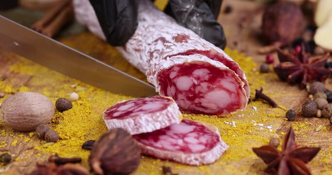 Cutting sausage with white mold, slicing salami with mold pieces for table setting