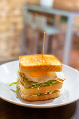 Vegetarian club sandwich with white bread, egg, green lettuce and cheese