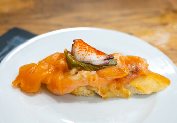 Board with typical snacks of Basque Country, pinchos or pinxtos, skewers or small piece of bread with toppings, served in bar in San-Sebastian or Bilbao, Spain