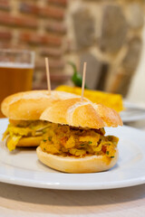 Typical mini burger snack of Basque Country, pinchos or pinxtos, small piece of bread with different toppings, served in bar in San-Sebastian or Bilbao, Spain