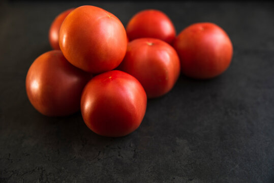 red tomatoes on a dark kitchen counter