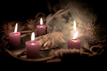 Pentagram amulet and black candle in autumn forest, natural background. Magic esoteric witches...