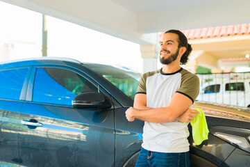 Attractive man finishing washing the car