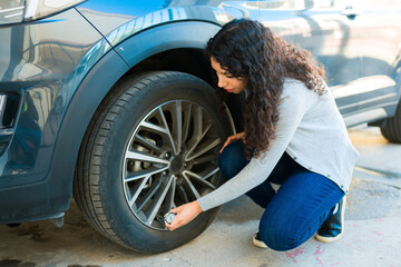 Woman checking the car tires
