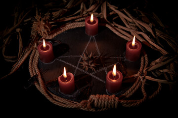 Voodoo doll, black candles, pentagram and old books on witch table. Occult, esoteric, divination and wicca concept. Mystic, voodoo and vintage background. - obrazy, fototapety, plakaty