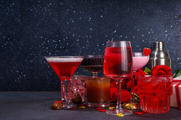 Valentine day romantic bar background. Set various red, pink, chocolate alcohol drinks for Valentine day party or dating, in different cocktail glasses with rose flower bouquet, heart decor, gift box