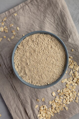 Organic White Oat Flour in a Bowl on a gray background, top view. Flat lay, overhead, from above.