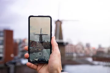 Fototapeten Ein Bild von einem Smartphone beim Fotografieren einer Windmühle in Rotterdam © Julian