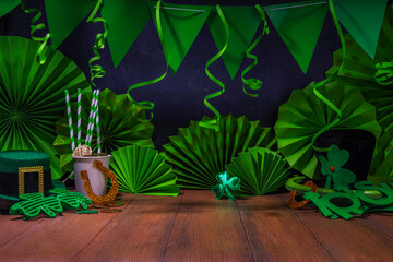 St. Patrick party invitation decorated background. Bar wooden table with various green decorations...