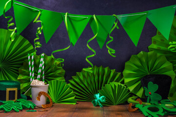 St. Patrick party invitation decorated background. Bar wooden table with various green decorations...
