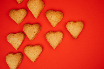 Shortbread cookies in the form of hearts on a red background. Background, Valentine's Day. Flat lay