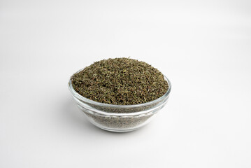 thyme dry leaves in a glass dish on a white background 