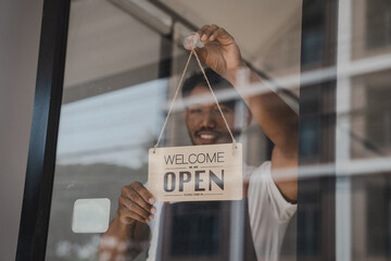 Young Asia coffee shop owner business man in apron with open sign at door shop.