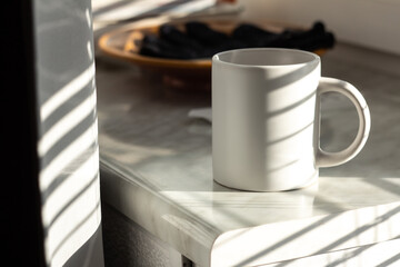 A white mug on the windowsill - 562098858