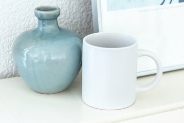 White mug on shelf. Artwork space