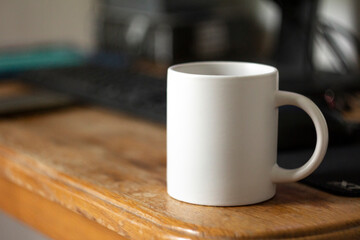 White mug on the desktop - 562099237
