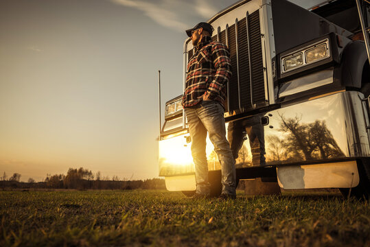 Trucker in Front of His Semi Truck During Sunset