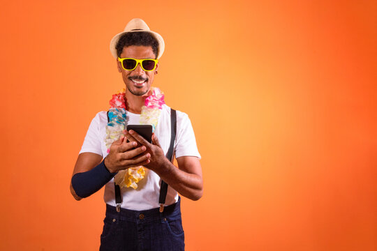 Portrait of Black Man With Carnival Props Isolated on Orange Background.