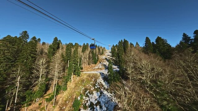 FPV sports freestyle drone raising big cabin cableway movement ropeway over autumn yellow pine trees forest sunny mountain valley aerial view. Natural woodland landscape travel outdoor winter leisure