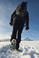 Man Walking On Snow With Shoe Spikes In Winter