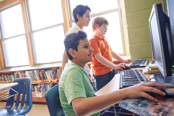 Learning, education and students on computer in classroom or middle school. Development, pc and group of boys or kids studying computers, information technology and software, coding or programming.